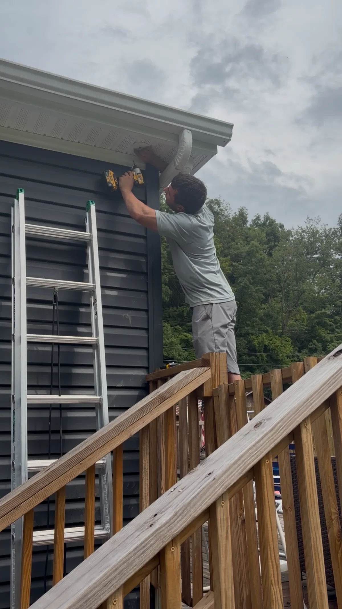An ODA installer drilling a dome security camera into the soffit of a home